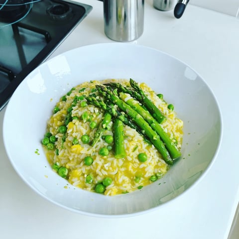 A bowl of rice with peas and asparagus.